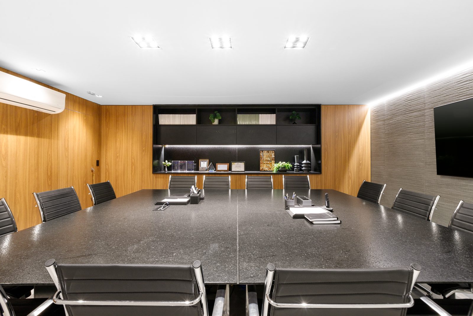Sala de reunião da sede de advocacia com mesa de pedra escura