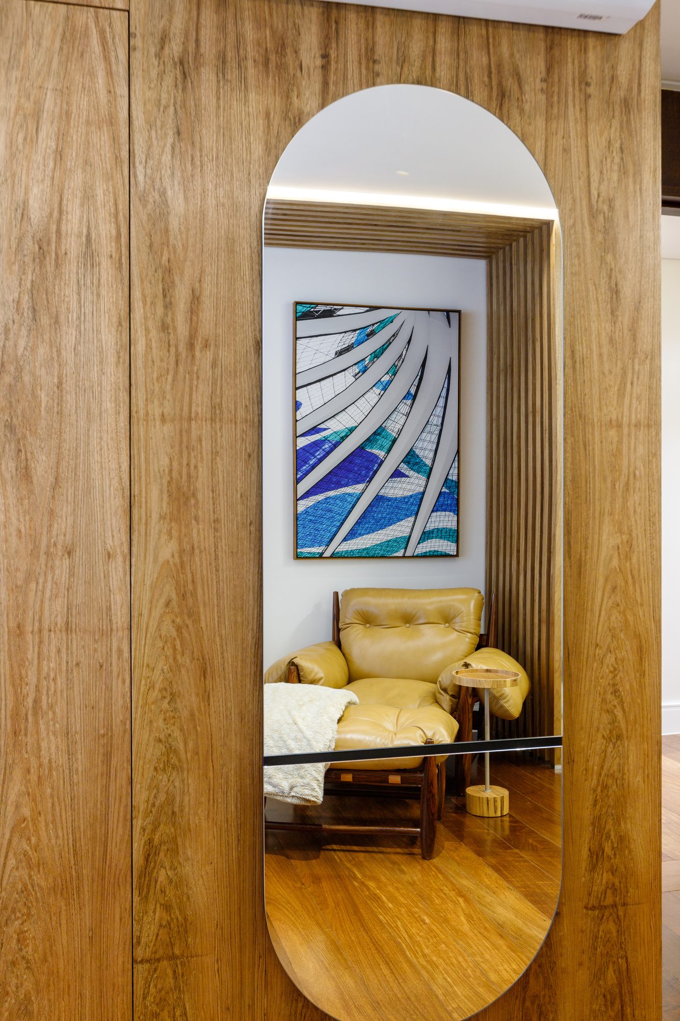 Espelho em arco no painel de madeira do Apartamento Asa Sul