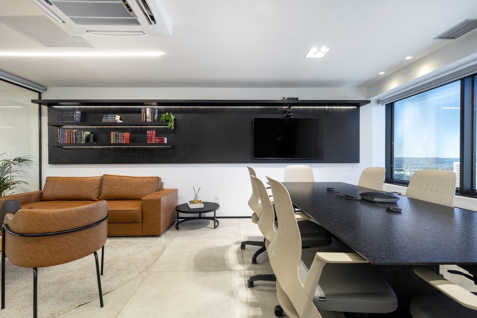 Escritório corporativo com estante preta e mesa de reunião